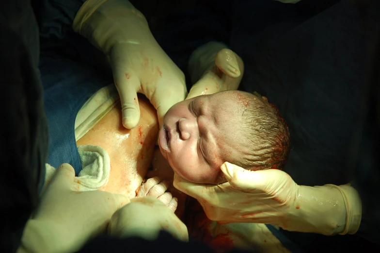 a person is holding a newborn infant on a lap
