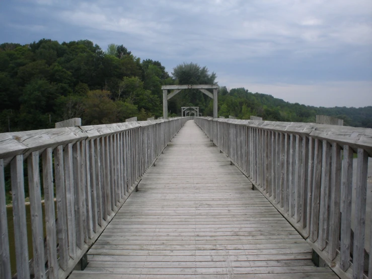 a very old looking wooden bridge crossing across the river