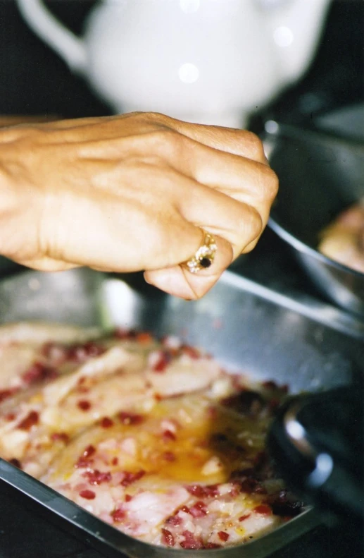 someone is putting some food in a pan