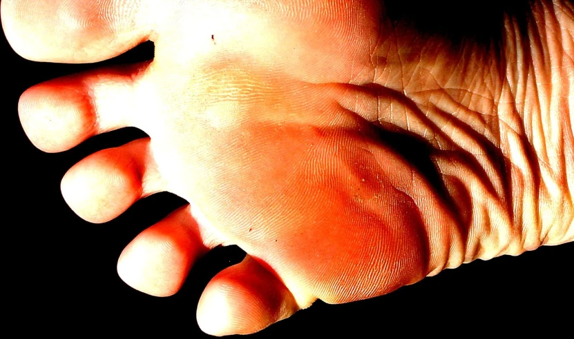 close up of the palm of a person with one hand and an orange object in the background