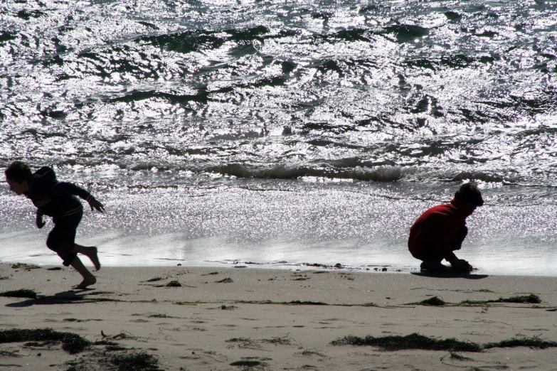 a couple of people on a beach next to the ocean