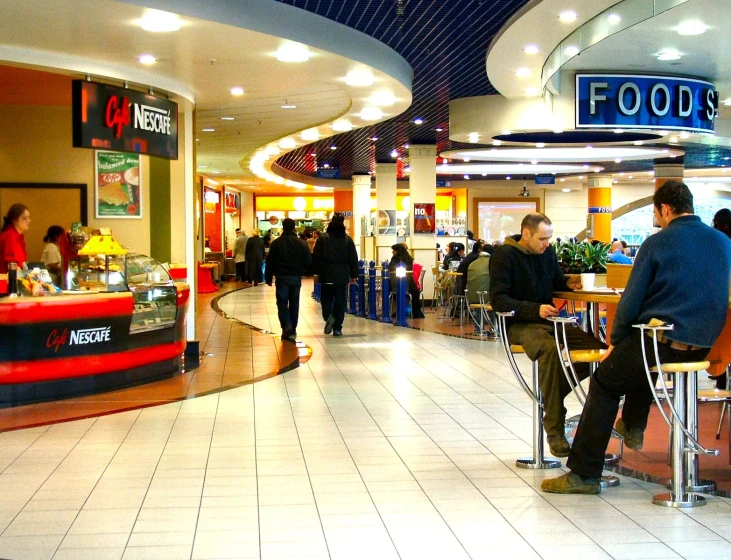 several people waiting at their lunch stations in an empty mall
