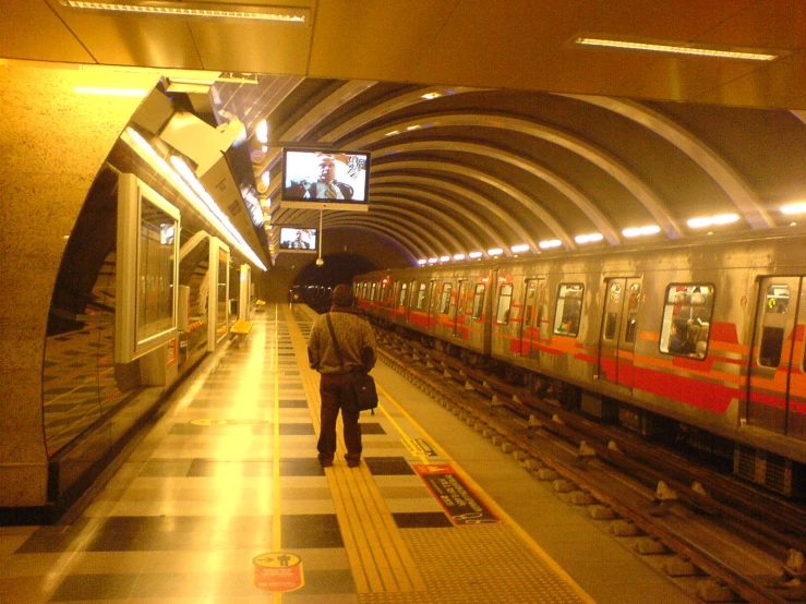 a man standing by a train at the station