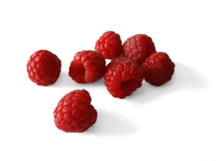 raspberries on white background laying on the floor