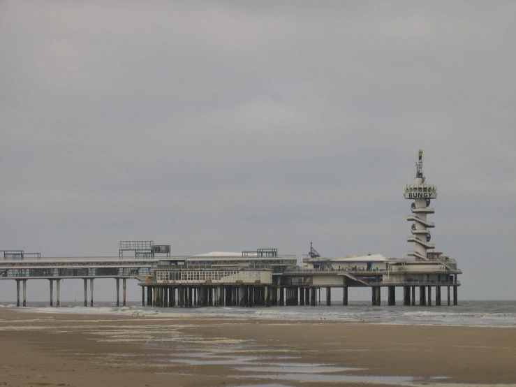 an empty beach with a pier in the middle