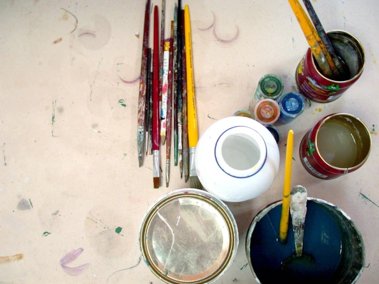 a table with some paint brushes and paints