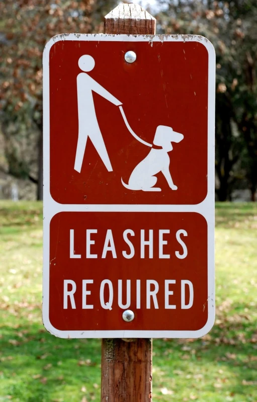 a sign stating to leashes required in a dog park