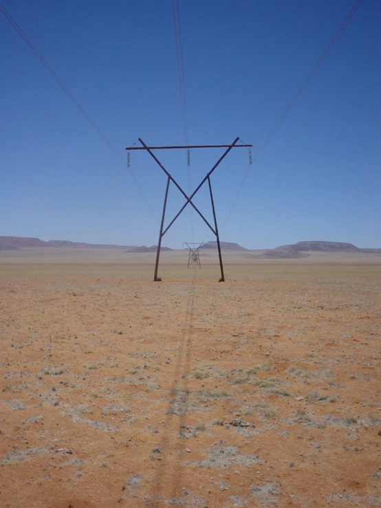 an electric line stands in a deserted desert field