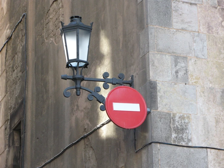 an ornate lamp attached to a lightpost above a street sign