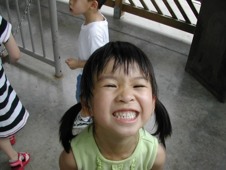 little girl standing with smiling face at outdoor play area