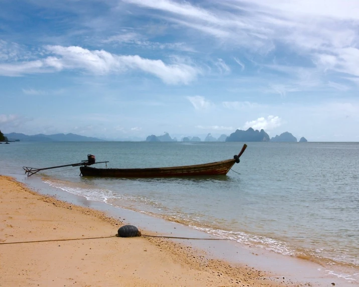 a boat sitting on top of a sandy beach