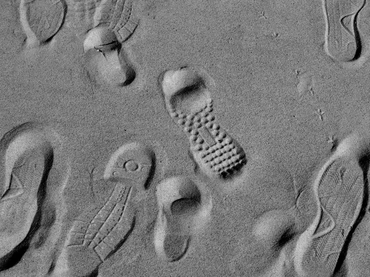 someone's footprints in the sand while walking with his foot