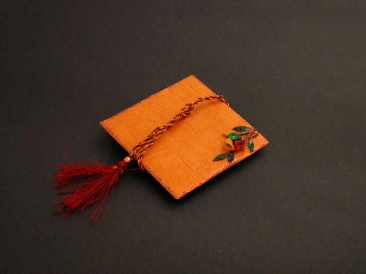 a yellow napkin with red tassel on it