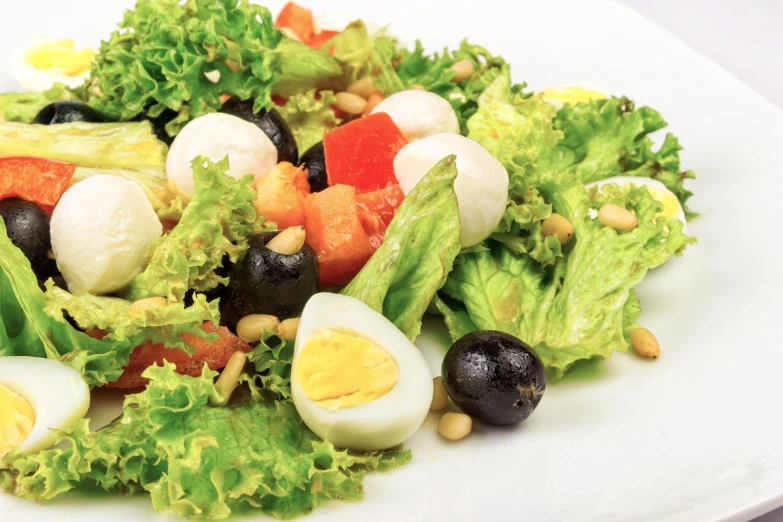lettuce and egg salad on a plate with a lemon