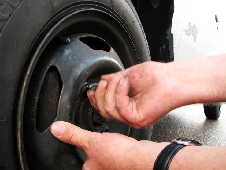 a person working on an empty tire on a vehicle