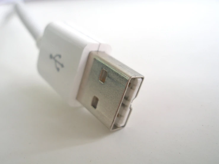 an unplugged white cell phone charger sitting on a counter