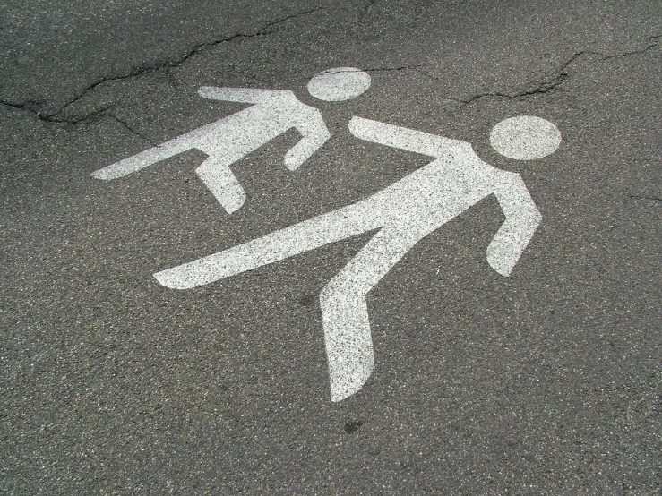 street sign for people crossing in crosswalk in urban setting