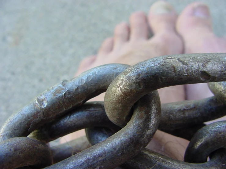 a feet sticking out of the ground, with a chain around them
