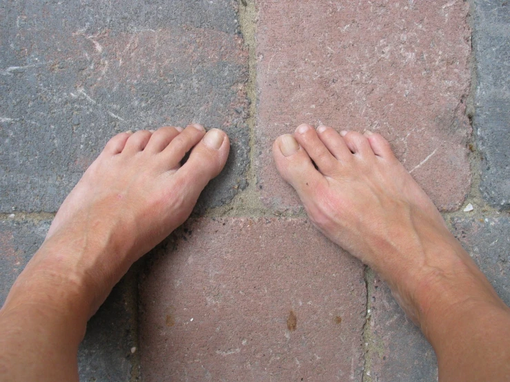 the feet of a person on an asphalt road