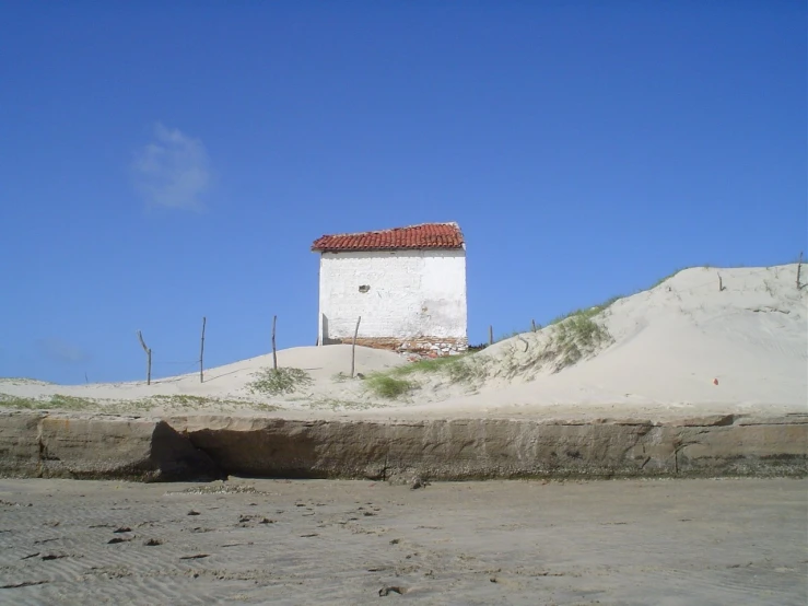 a building with a roof in the sand