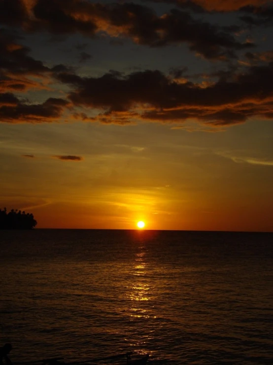 the sun sets in between two large islands