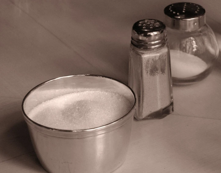 this is a bowl and salt shaker on a table