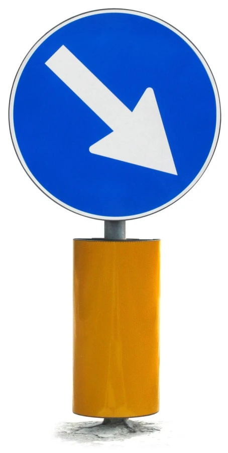 a street sign in two languages and a curvy arrow
