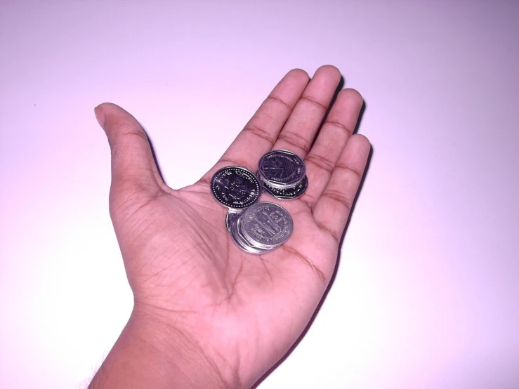 two coins are being held in a hand