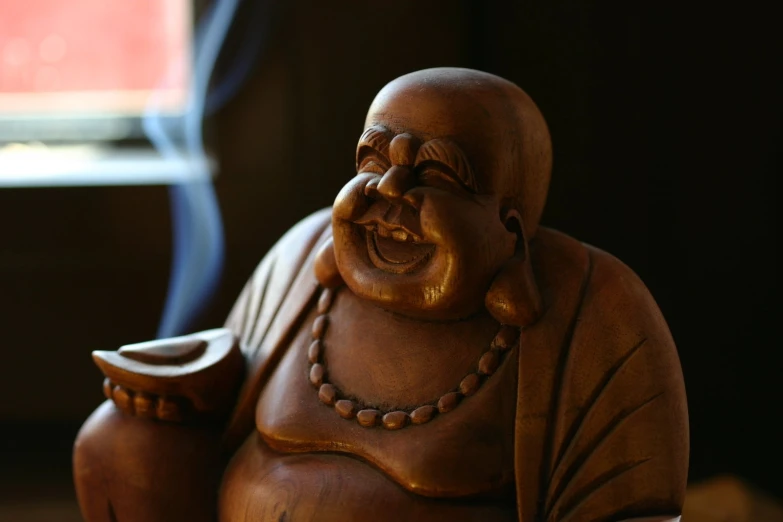 a wooden carving of an asian man