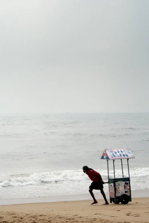 a person with luggage walks towards the ocean