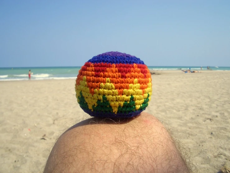 the back of a person with a crocheted hat at the beach