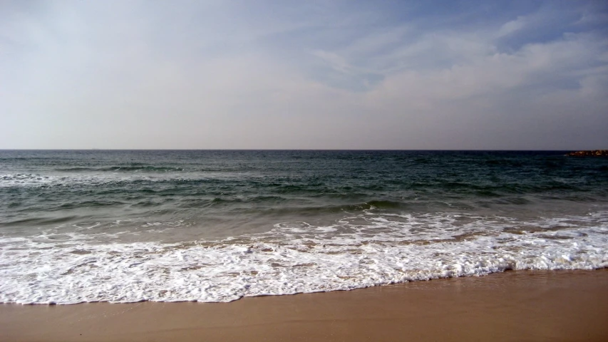 waves and sand at the beach near the shore