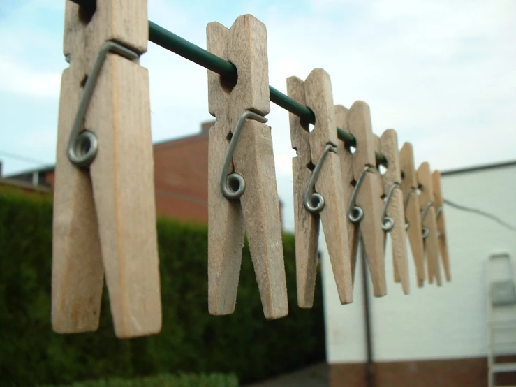 several wooden clothes pins with clips attached to them