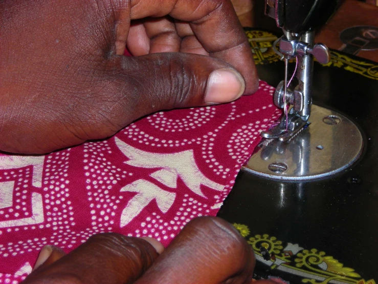 someone is sewing a piece of cloth using a sewing machine