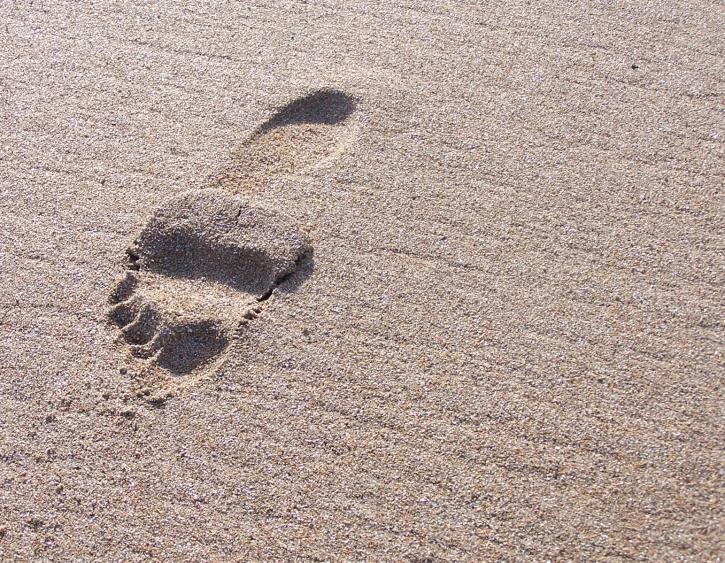 an imprint in the sand of someone's foot