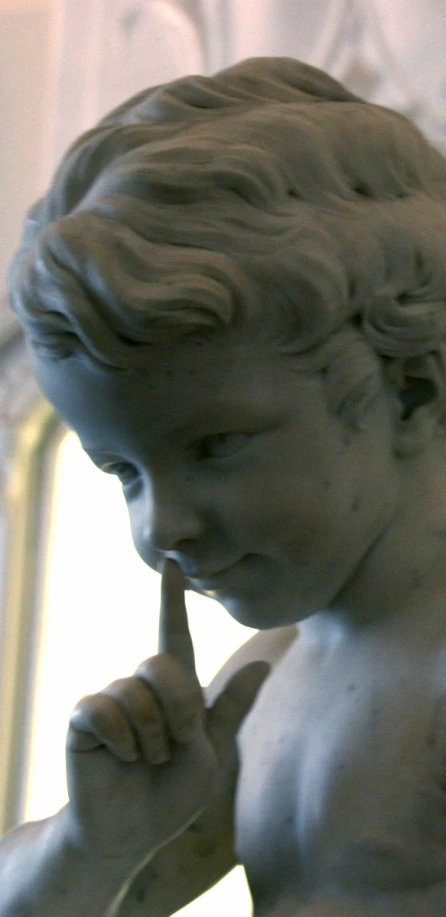 a close up of a statue holding a toothbrush