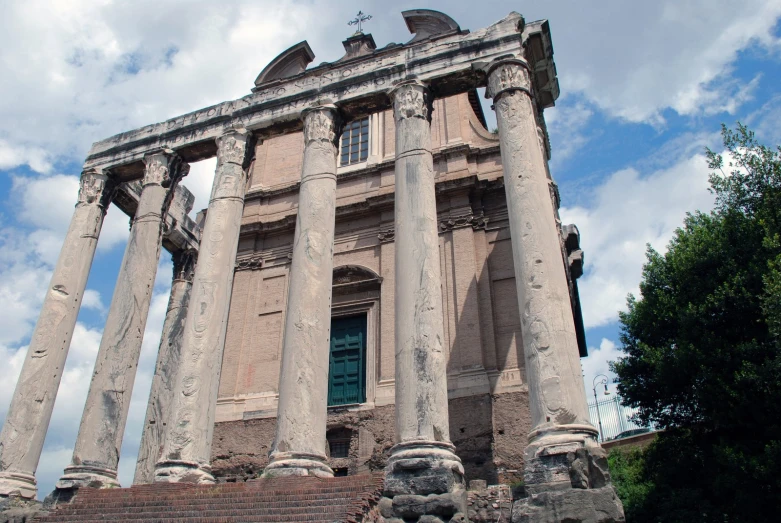 ancient architecture against a partly cloudy sky and trees