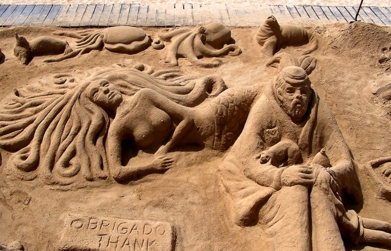 a sand sculpture depicting a human figure at the bottom