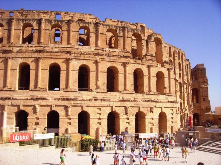 many people are walking around an ancient building