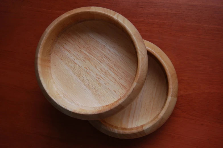 two empty bowls sitting on top of a wooden table