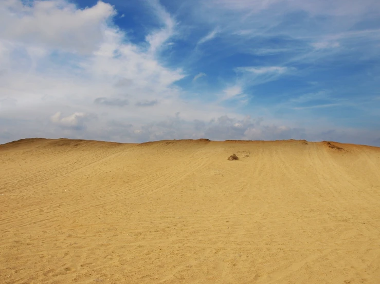 a barren, sandy area with blue skies above