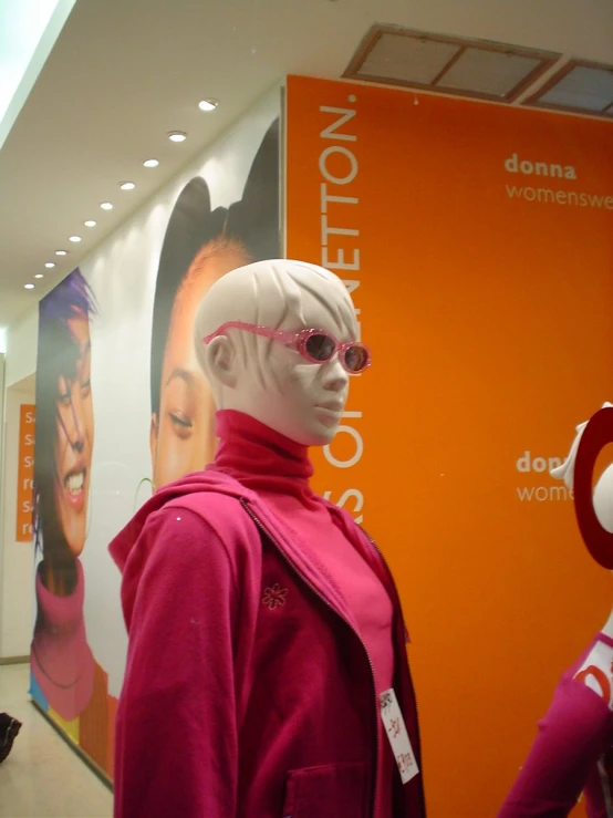 a mannequin dressed in pink in front of a window display