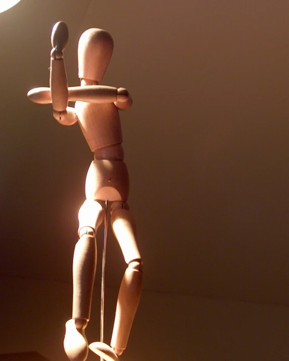 a wooden toy figurine that has a light above him