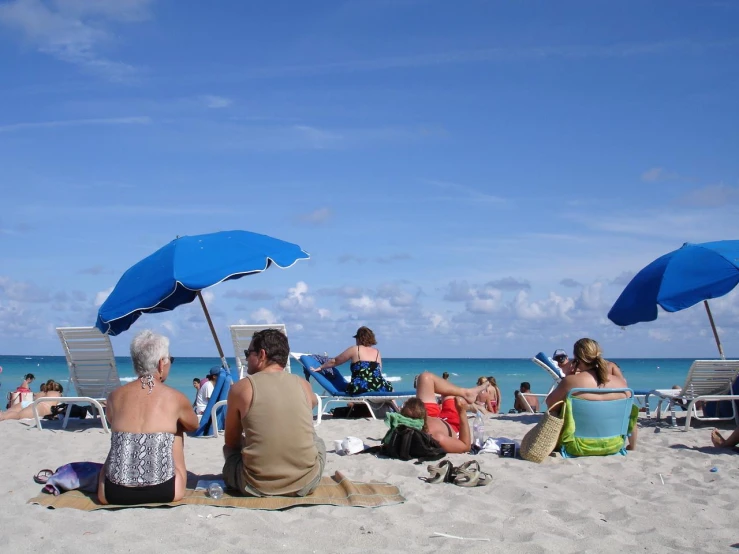 a group of people sitting on top of a beach