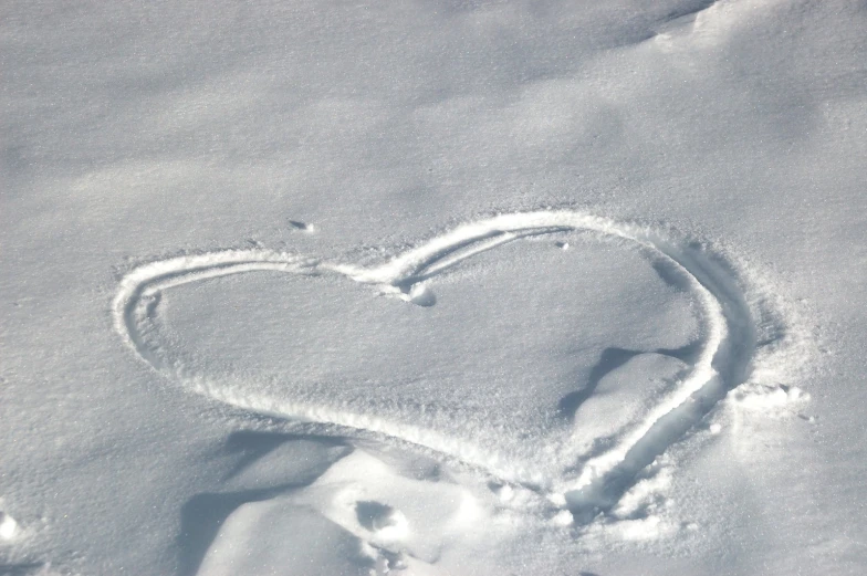 a white heart drawn in the snow by someone