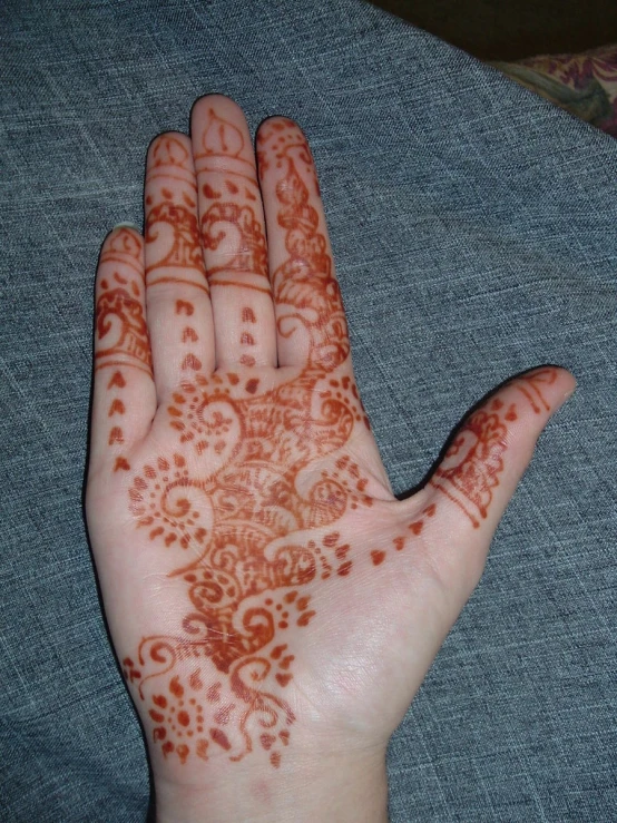 someone with henna painted on their palm shows the pattern of dots