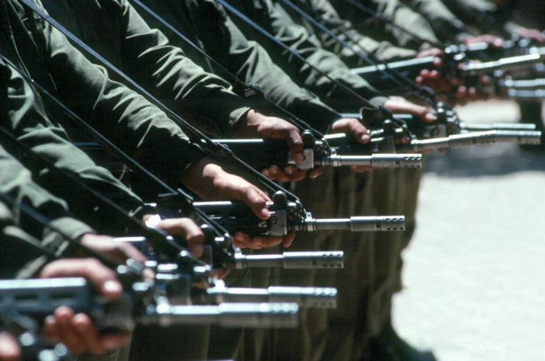 a line of people wearing green uniforms holding guns