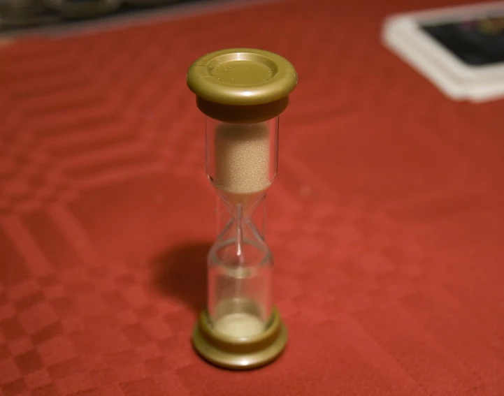 a glass timer in an hourpiece sitting on a table