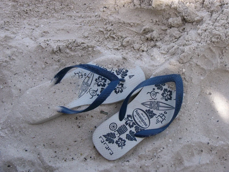 pair of white sandals on sandy area during daytime