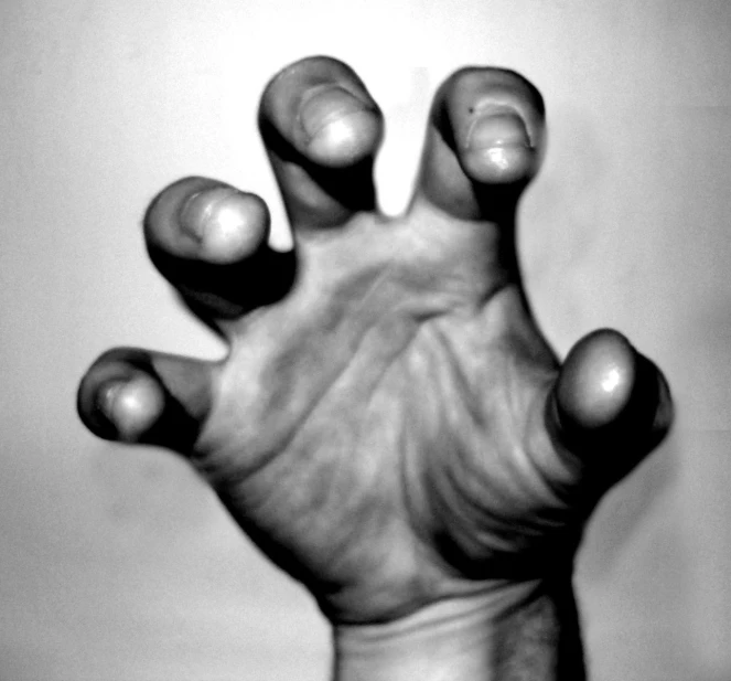 a black and white po of a hand reaching up towards the sky